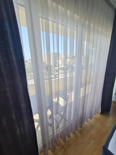 a room with a window with white curtains at Apartment 1 Plisi Gjilan in Gjilan