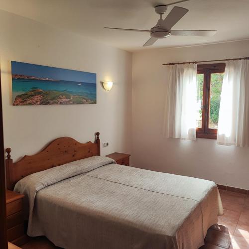 a bedroom with a bed and a ceiling fan at O7 Vistapicas in Cala en Blanes
