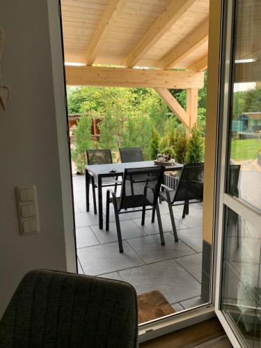 a screened in patio with a table and chairs at Ferienwohnung Rotbuche in Tannenberg