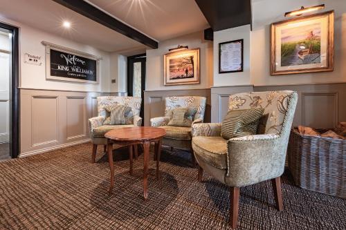 a waiting room with three chairs and a table at The King William IV - The Coaching Inn Group in Sedgeford