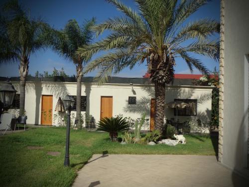 a white house with palm trees in the yard at Jnane Ville Verte in Casablanca
