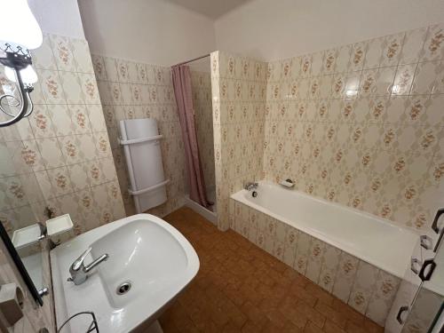 une salle de bain avec une baignoire, des toilettes et un lavabo dans l'établissement L hacienda de Raymonde, à Nîmes