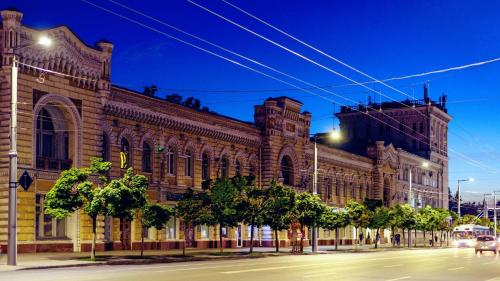 a large brick building on a street at night at Vasile Alecsandri 60 ap 49 in Chişinău