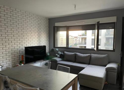 un salon avec un canapé et une télévision dans l'établissement T2 moderne sud Aix en Provence, à Aix-en-Provence