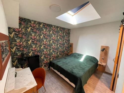una camera da letto con un letto con un piumone verde di Appartement neuf au coeur du vignoble dans village tous commerces a Cahuzac-sur-Vère