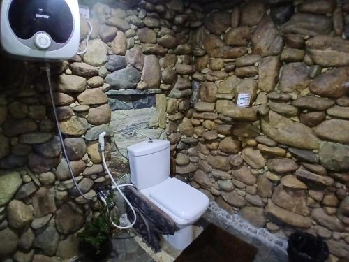 a stone bathroom with a toilet and a camera at Awesome Place in Ella