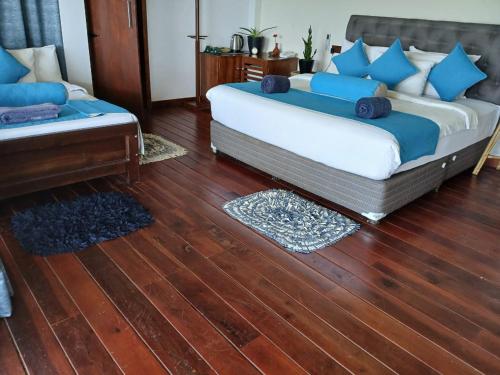 a bedroom with two beds and a wooden floor at Awesome Place in Ella