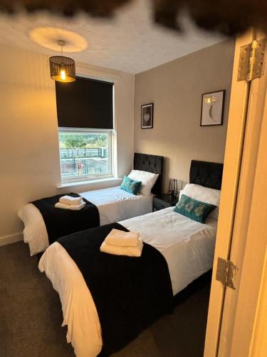 a bedroom with two beds and a window at Stunning House - Sleeps 7 - 5 Mins walk to Lincoln High Street - Parking - Wifi in Lincolnshire