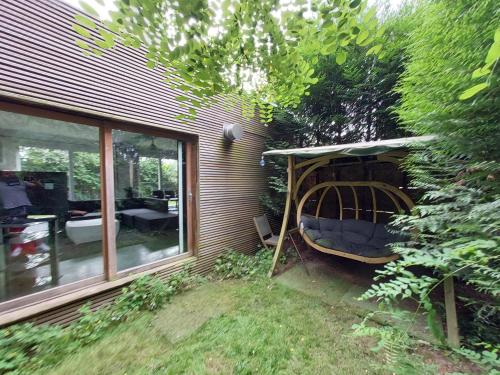 a garden with a swing in the corner of a house at Lake Harelbeke in Harelbeke