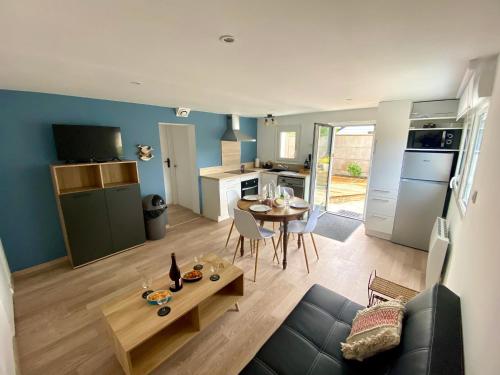 un salon avec un canapé et une table et une cuisine dans l'établissement La mélodie des Vagues, à Portbail