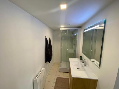 une salle de bain avec un lavabo et une douche dans l'établissement La mélodie des Vagues, à Portbail