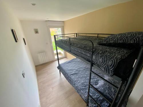 une chambre avec un lit superposé dans une pièce dans l'établissement La mélodie des Vagues, à Portbail