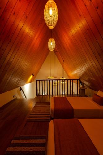 a bedroom with two beds and a chandelier at Majentra Ella in Ella