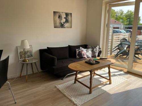 a living room with a black couch and a table at Kalundborg centrum in Kalundborg