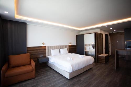 a bedroom with a bed and a chair and a desk at Batumi View Luxury in Batumi