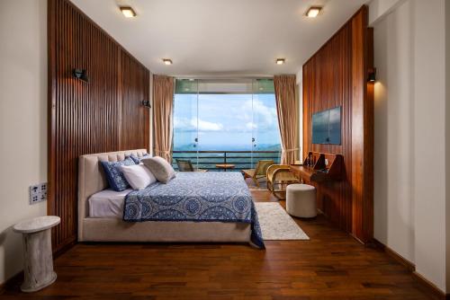 a bedroom with a bed with a view of the ocean at Majentra Ella in Ella