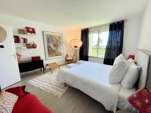 une chambre avec un grand lit blanc et une fenêtre dans l'établissement PGH N24 - Duplex sur le Port avec Parking Privé, à La Grande Motte