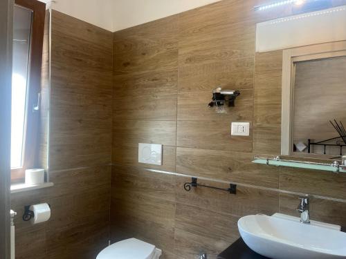 a bathroom with a sink and a toilet and a mirror at La Chianconata in Vieste
