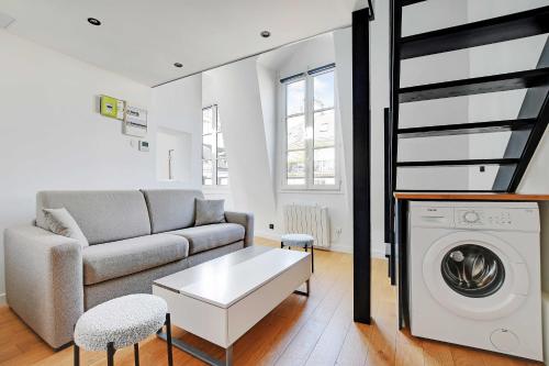 un salon avec un canapé et une machine à laver dans l'établissement Charming apt with ac -Rue des Archives- le marais, à Paris