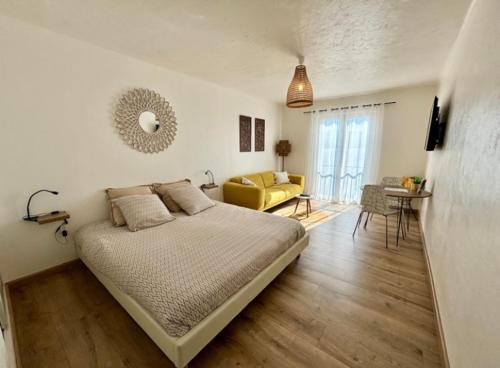 - une chambre avec un lit et un canapé jaune dans l'établissement Pieds dans l'eau, sur une plage, à Casaglione