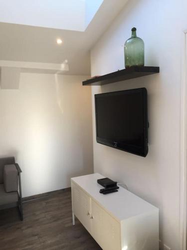 un salon avec une télévision à écran plat sur un mur dans l'établissement Vannes centre , maison 2 chambres avec jardin,SPA, à Vannes