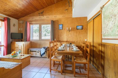 a dining room with a wooden table and chairs at Résidence Les Balcons De Val Cenis Le Haut in Lanslevillard