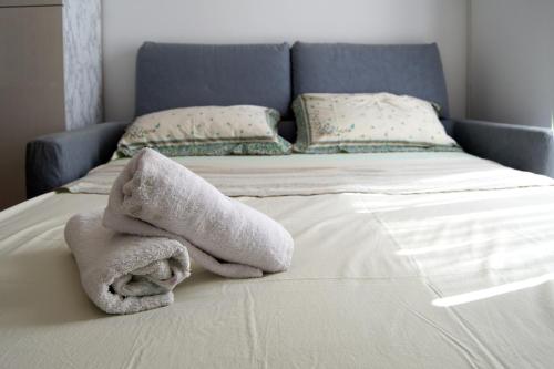 a bed with a pile of towels on it at Peschici Central Room - vista mare in Peschici