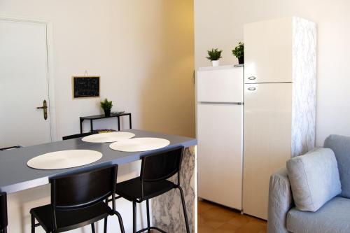 a kitchen with a table and a refrigerator at Peschici Central Room - vista mare in Peschici