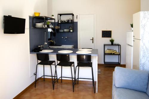 a kitchen with a counter with four chairs around it at Peschici Central Room - vista mare in Peschici