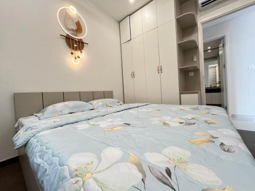 a bedroom with a large bed with flowers on it at Căn Hộ cao cấp The Emerald Golf View Thuận An Bình Dương in Thuan An