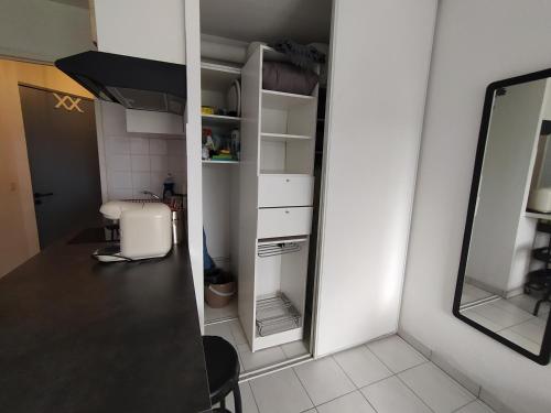 - une petite cuisine avec un comptoir et un miroir dans l'établissement Cosy Angelu, à Anglet
