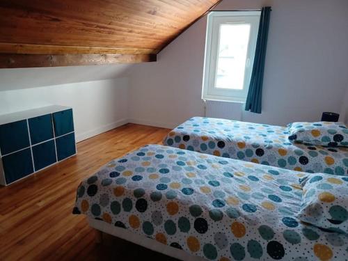 a bedroom with two beds and a window at Gite du Bois Rosé in Fécamp