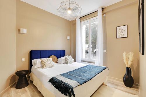 - une chambre avec un lit doté d'une tête de lit bleue et d'une fenêtre dans l'établissement Lovely apartment - 1BR-4P - Buttes-Chaumont, à Paris