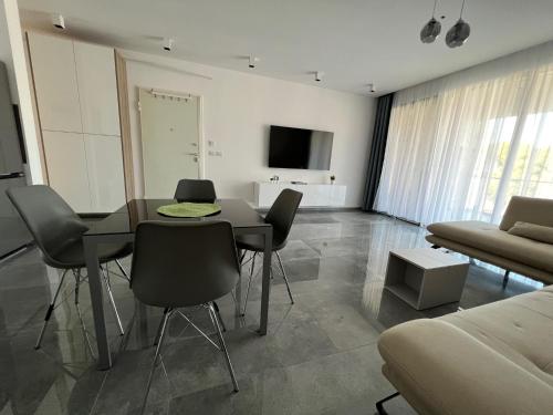 a living room with a table and chairs and a couch at Rent Apartament Lalzy Bay in Durrës