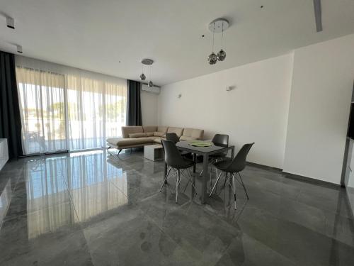 a living room with a table and chairs and a couch at Rent Apartament Lalzy Bay in Durrës