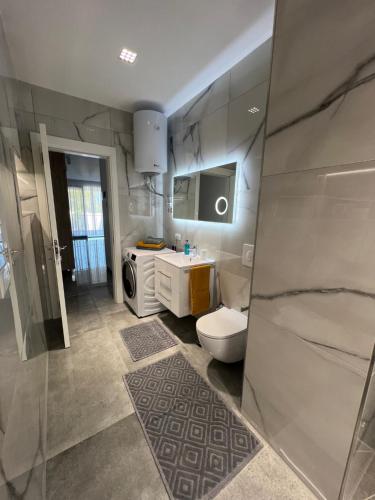 a bathroom with a toilet and a sink at Rent Apartament Lalzy Bay in Durrës