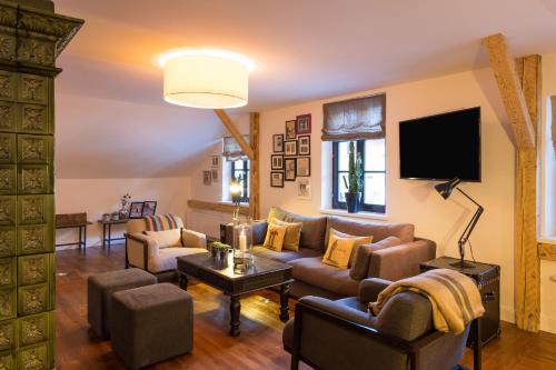 a living room with a couch and chairs and a tv at Raffl's Sweet Little Home in Sankt Anton am Arlberg