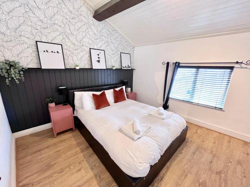 a bedroom with a bed with white sheets and red pillows at Ropewalks City Centre Apartment with Roof Terrace in Liverpool