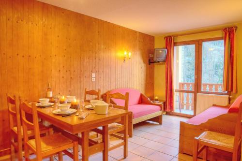 a dining room with a table and a couch at Résidence Les Balcons De Val Cenis Le Haut in Lanslevillard
