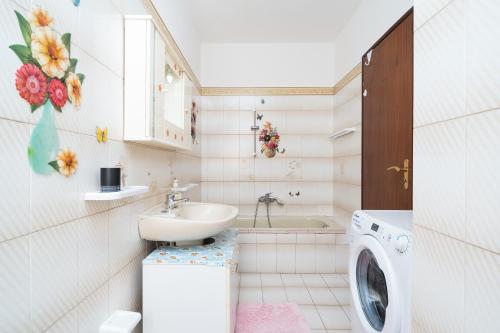 a bathroom with a sink and a washing machine at Casa Monica in Posada