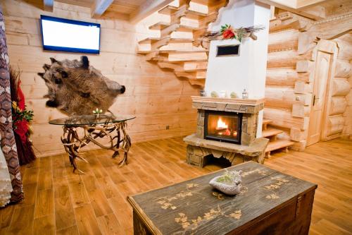 a log cabin living room with a fireplace at Domki Prokop in Ciche