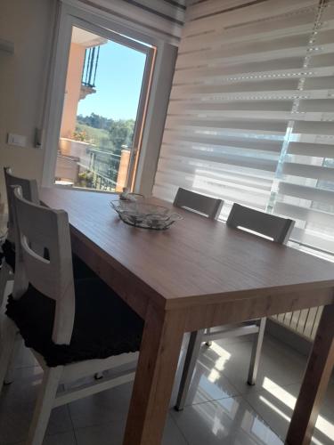 Una mesa de comedor con sillas y una gran ventana. en Apartamento Avenida Constitución, en Boiro