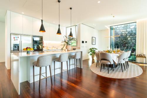a kitchen and dining room with a table and chairs at Refúgio na Escarpa Luxury Villa in Quinta Grande