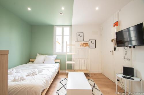 une petite chambre avec un lit et une télévision dans l'établissement Studio calme proche Vilaine - Ty ar Sant-Elier, à Rennes