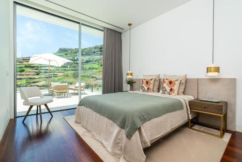 a bedroom with a bed and a large window at Refúgio na Escarpa Luxury Villa in Quinta Grande