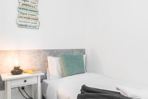 a bedroom with a bed and a side table at Home2Book Stunning BeachFront Apt, Pozo Izquierdo in Pozo Izquierdo
