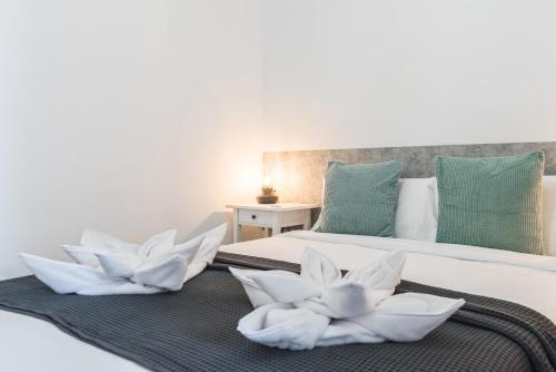 a bedroom with two beds with white flowers on them at Home2Book Stunning BeachFront Apt, Pozo Izquierdo in Pozo Izquierdo
