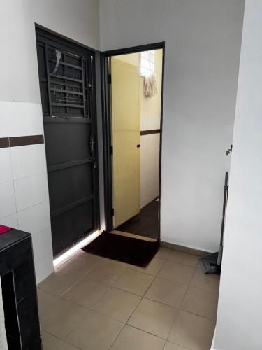 a hallway with a door and a tile floor at Jagapuri Homestay Jasin Melaka in Jasin