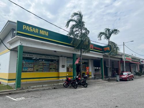 two motorcycles parked in front of a pizza store at Jagapuri Homestay Jasin Melaka in Jasin