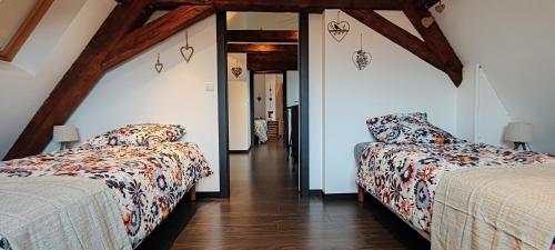 2 bedden in een kamer met houten plafonds bij La Grenouille - Centre Ville - Proche Parking Gratuit - Commerces à Proximité in Sélestat